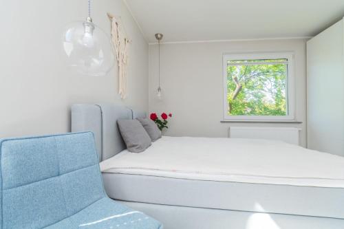 ソポトにあるSzary & Zielony by Grand Apartmentsのベッドと窓のある白い部屋