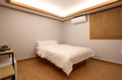 a small bedroom with a bed and a ceiling at 신림 유호텔 Seoul Sillim U Hotel - 고양이와 보드게임이 있는 힐링 숙소 in Seoul