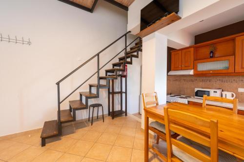 a room with a wooden table and a stairway at Spedion Villa - Near to sea villas with heated swimming pool in Gythio