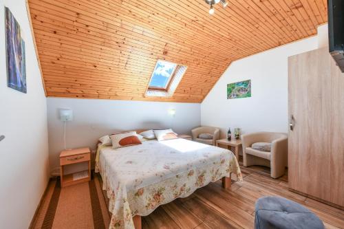 a bedroom with a bed and a wooden ceiling at Apartment & Rooms Luketic in Rastovača