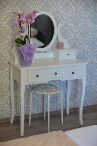 a white dressing table with a mirror and a chair at Casetta Valderoa Fiumicino in Fiumicino