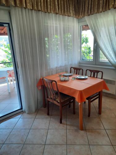 a dining room with a table and chairs and windows at Vasilis Garden House in Kavala