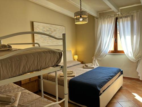a bedroom with two bunk beds and a window at Casa vacanze La Chicca in Capo dʼOrlando