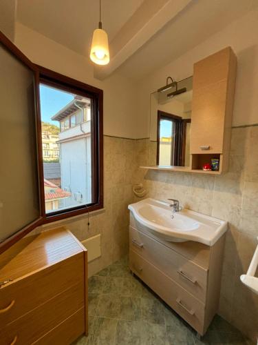 ein Badezimmer mit Waschbecken und Fenster in der Unterkunft Casa vacanze La Chicca in Capo dʼOrlando