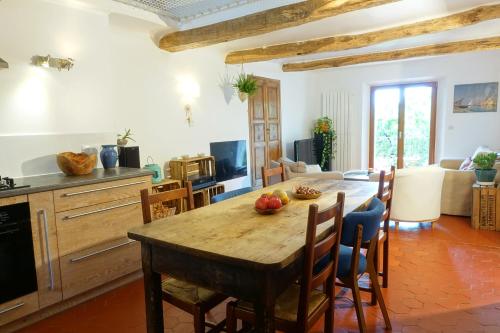 une cuisine et une salle à manger avec une table et des chaises en bois dans l'établissement Grande maison de village 200 m2 calme tout confort, à Gréolières