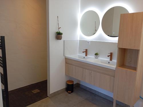 une salle de bain avec deux lavabos et deux miroirs dans l'établissement Appart Binic - Le grain de beauté, à Binic