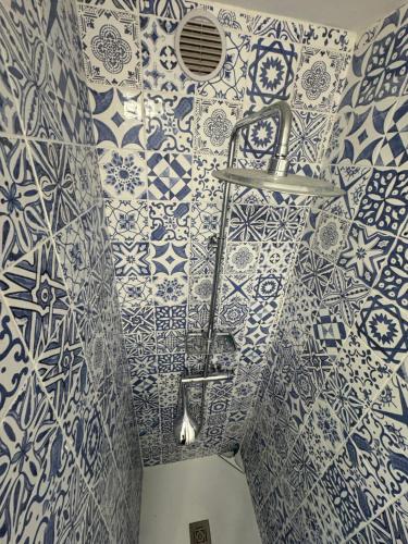 La salle de bains est revêtue de carrelage bleu et blanc. dans l'établissement #T03 DUCAL MARINA BAIE DES ANGES avec Terrasse, à Villeneuve-Loubet