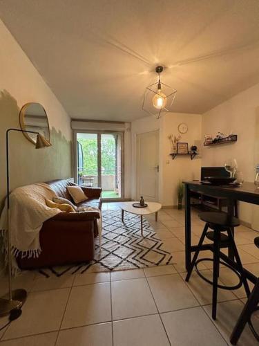 un salon avec un canapé et un bureau dans l'établissement Le Green Pont Jumeaux - T2 - Parking - Vue Canal, à Toulouse