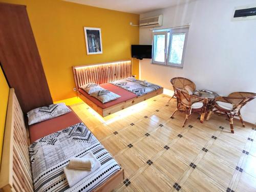 a room with two beds and a table in it at Durakovic Apartments in Herceg-Novi