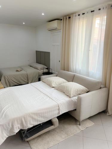 - une chambre blanche avec 2 lits et un canapé dans l'établissement République, à Nice
