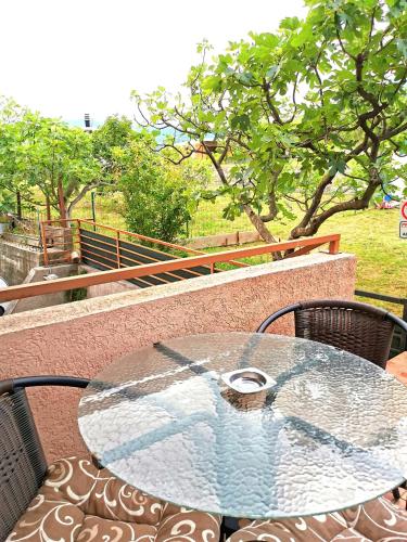 a glass table and chairs on a patio at Durakovic Apartments in Herceg-Novi
