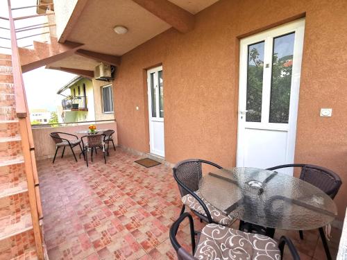 a patio with a table and chairs on a porch at Durakovic Apartments in Herceg-Novi