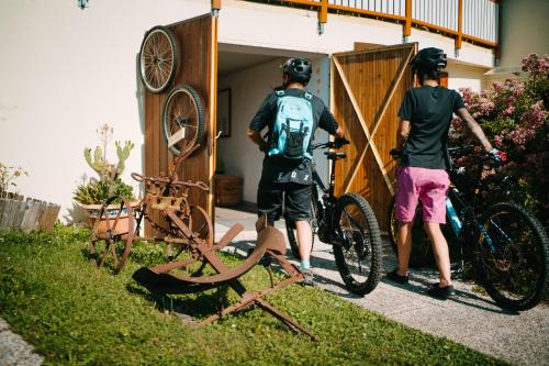 two men standing next to a bike in a yard at Ferienwohnungen Theresienhof in Ledenitzen