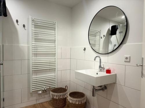 a white bathroom with a sink and a mirror at Ankerplatz in Tönning