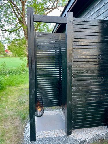 a wooden gate with a cat inside of it at Koselig hytte på eget tun med varmtvanns utedusj in Ås