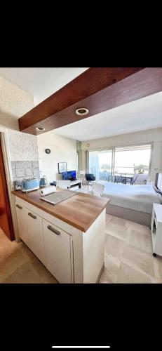 une cuisine et un salon avec un canapé et une table dans l'établissement #101 MARINA RIVIERA BAY - Studio 30m2 avec terrasse vue Mer, à Villeneuve-Loubet