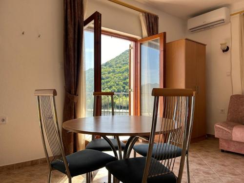 a dining room with a table and chairs and a window at Sunny Terraces in Cetinje