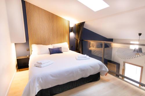 a bedroom with a large bed with white sheets at Loft Cocoon Spa in Nîmes