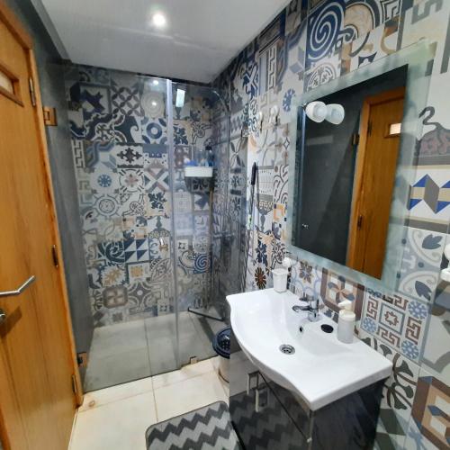 a bathroom with a sink and a shower at Le clapotis de la mer in Kenitra