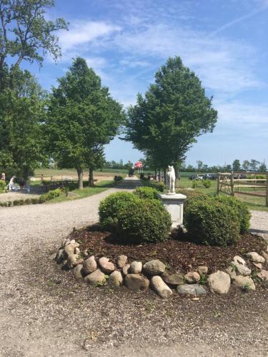 a park with a statue and bushes and a path at Øbjerggaard in Ebberup