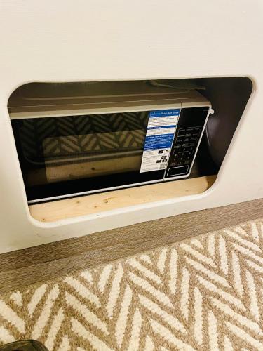 a microwave sitting on a shelf in a room at Streamside Shinytiny Airstream In The Smokies in Cosby