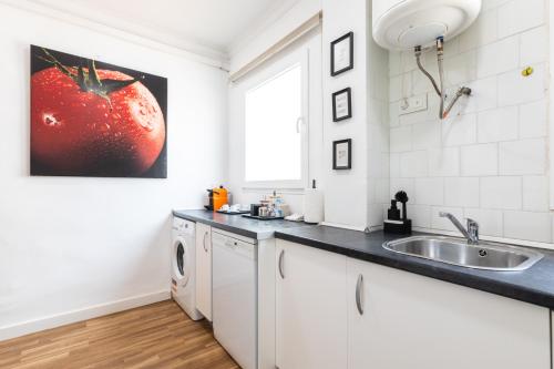 a kitchen with a sink and a washing machine at Mestalla River Apartment in Valencia