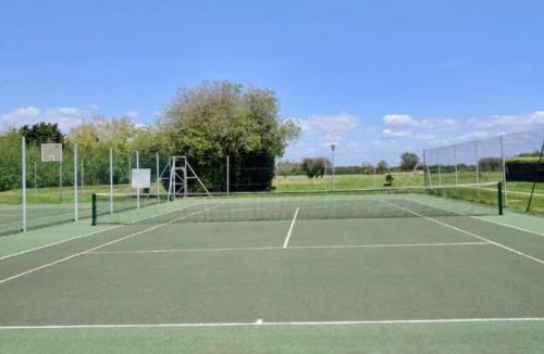a tennis court with a net on top of it at 50 Toledo, Selsey Country club in Selsey