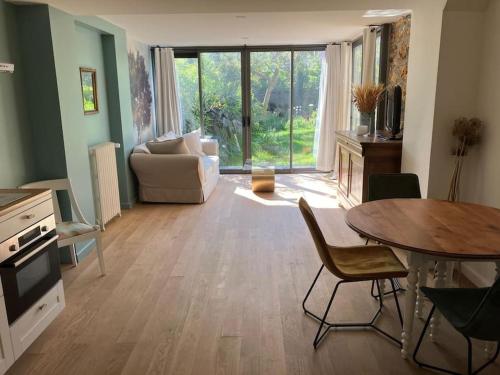 un salon avec une table et un canapé dans l'établissement Rez-de-jardin à 15 min de Paris, à Alfortville