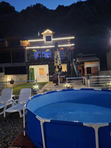 a swimming pool in front of a house at night at Vila Gavrić in Zvornik