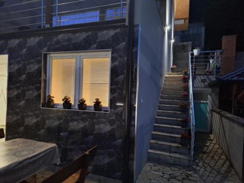 a staircase with potted plants in a window at Vila Gavrić in Zvornik