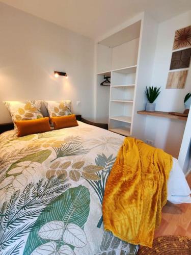 une chambre avec un lit avec une couverture jaune dessus dans l'établissement Grand studio face mer, à Saint-Georges-de-Didonne