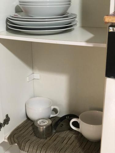 a shelf with plates and bowls on a shelf with a table at Casas Aracaju Temporada inteira 900 m da passarela in Aracaju