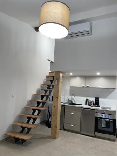 a kitchen with a spiral staircase in the middle of a room at Duplex raffiné, élégant & climatisé - La MEZZ in Nîmes