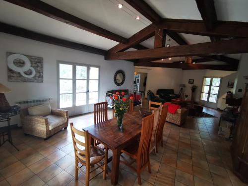 un salon avec une table et des chaises en bois dans l'établissement Location Cévennes - Maison familiale 10 couchages sur les hauteurs d'Anduze 30140, à Anduze