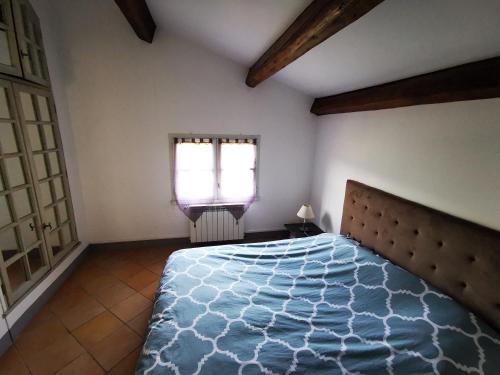 une chambre avec un lit et une fenêtre dans l'établissement Location Cévennes - Maison familiale 10 couchages sur les hauteurs d'Anduze 30140, à Anduze