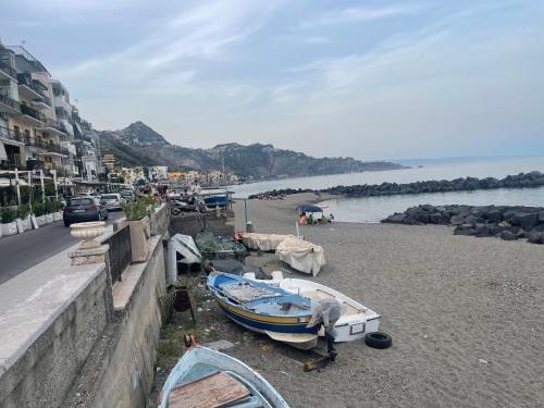 a boat sitting on the shore of a beach at MARIDDA-experience rooms- in Giardini Naxos