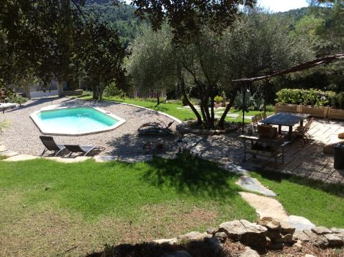 une piscine dans une cour avec une table et des chaises dans l'établissement Location Cévennes - Maison familiale 10 couchages sur les hauteurs d'Anduze 30140, à Anduze