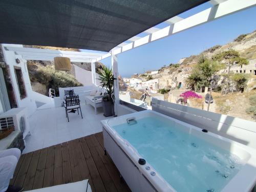 a hot tub on the balcony of a house at The Magic Luxury Cave Suites in Vóthon