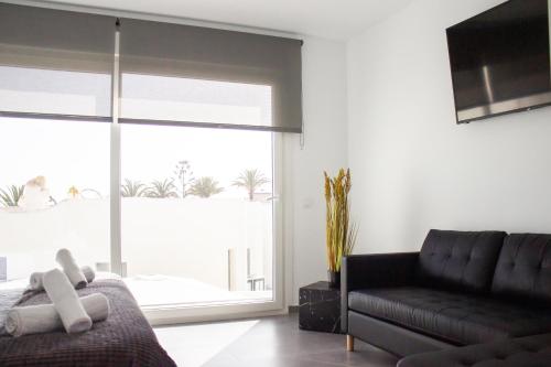 a living room with a couch and a large window at Gaviotas Beach Golf in Almerimar