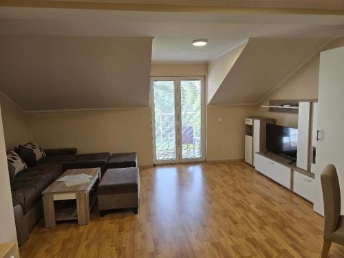 a living room with a couch and a television at Prenociste jezerske zvezde in Veliko Gradište