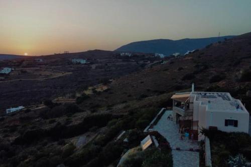 a house on a hill with the sunset in the background at Alexandria Aegean View in Gavrion