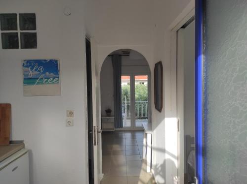 a hallway with an archway and a door in a house at Noula Rooms in Makrýgialos