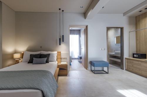 a bedroom with a large bed and a blue stool at El Mar Naxos in Naxos Chora