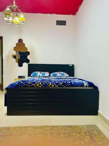 a bedroom with a bed with a blue comforter at Elite Class Furnished Room in Ajman 