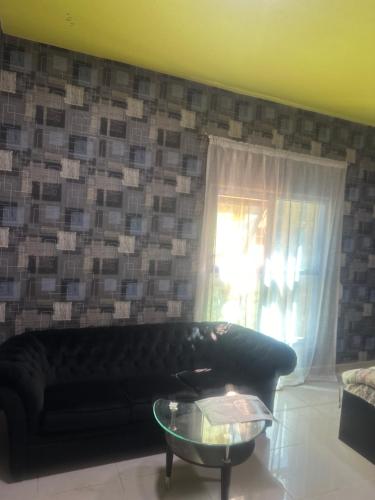 a living room with a black couch and a window at Elite Class Furnished Room in Ajman 