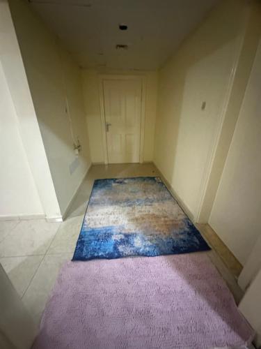 an empty room with a purple rug and a door at Elite Class Furnished Room in Ajman 