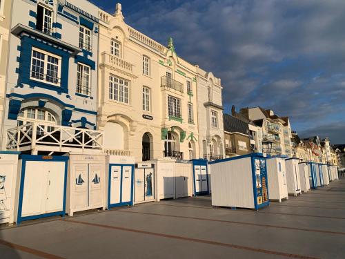 a building with blue and white doors on a street at Villa L'oie bleue-Terrasse- Plage 5 min vélo in Wimereux