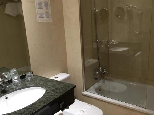a bathroom with a sink and a toilet and a shower at Hotel Pradillo Conil in Conil de la Frontera