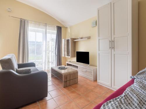 a living room with a couch and a tv at Ferienwohnungen und Appartements im idyllischen Vierkanthof, Gruppenurlaube in Loipersdorf bei Fürstenfeld