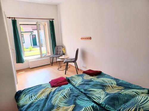 a bedroom with a bed and a chair and a window at Ferienwohnungen und Appartements im idyllischen Vierkanthof, Gruppenurlaube in Loipersdorf bei Fürstenfeld